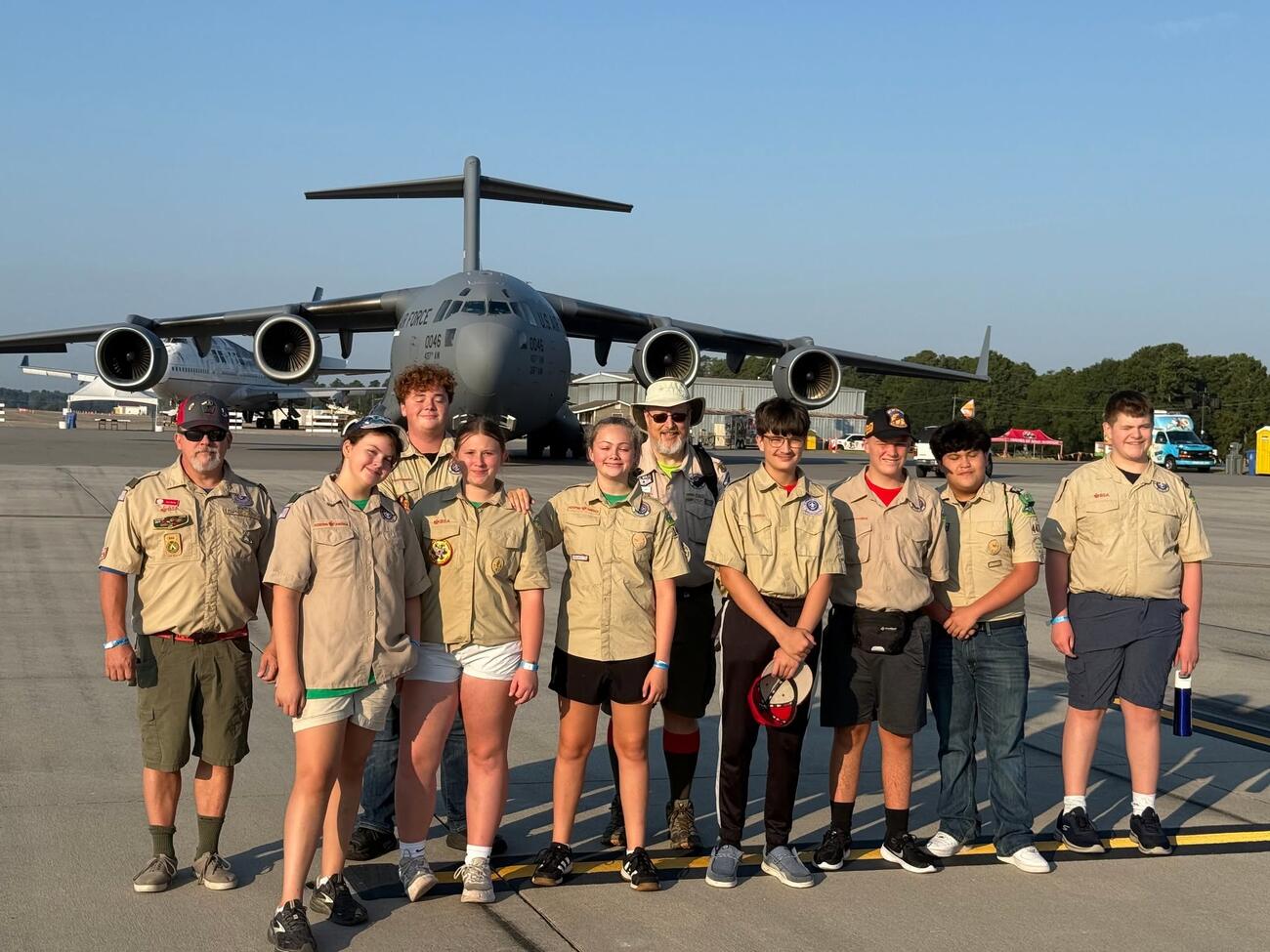 Scouts and leaders from Troop 447 and Troop 1447 in field uniform in front of a C-17 aircraft at the Maxton Airshow