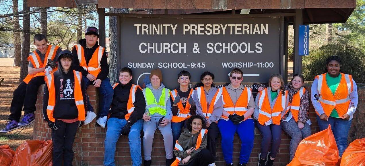 Scouts in safety vests with collected trash bags outside Trinity Presbyterian Church